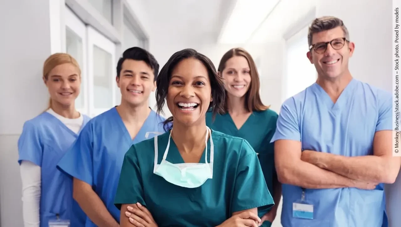 Multikulturelles lächelndes Team in Klinikkleidung