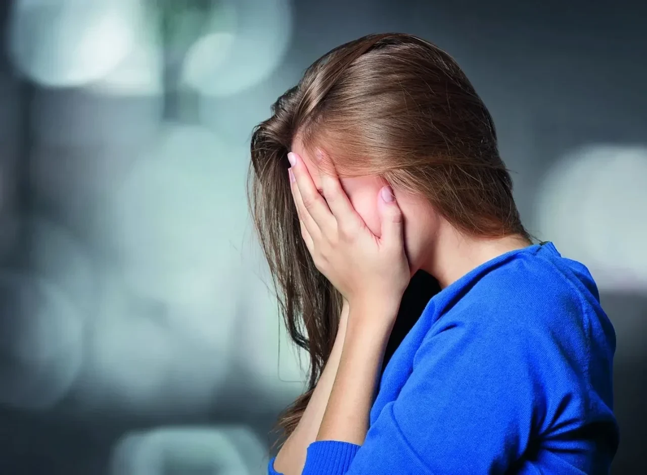 Pflegefachkraft hält sich die Hände vor das Gesicht