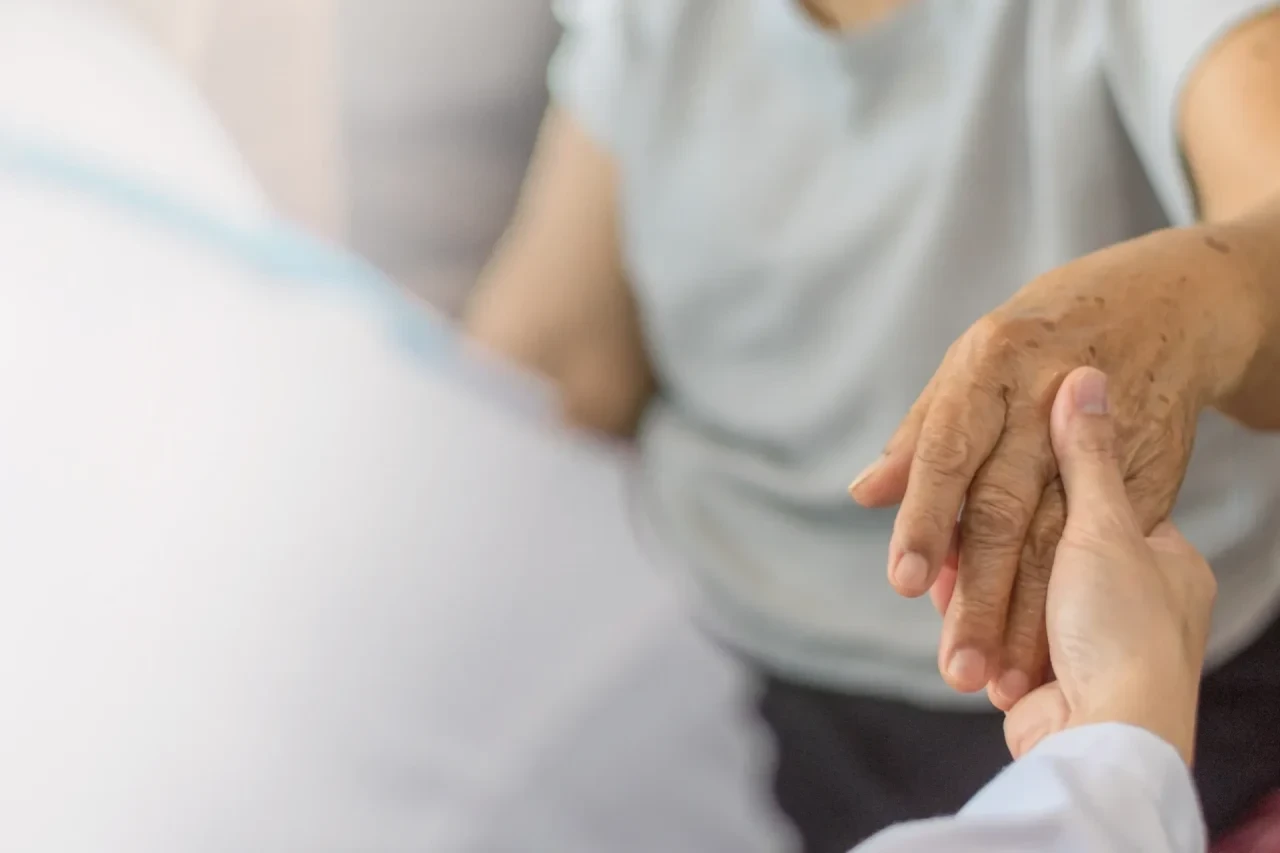 Arzt reicht Patientin unterstützend die Hand