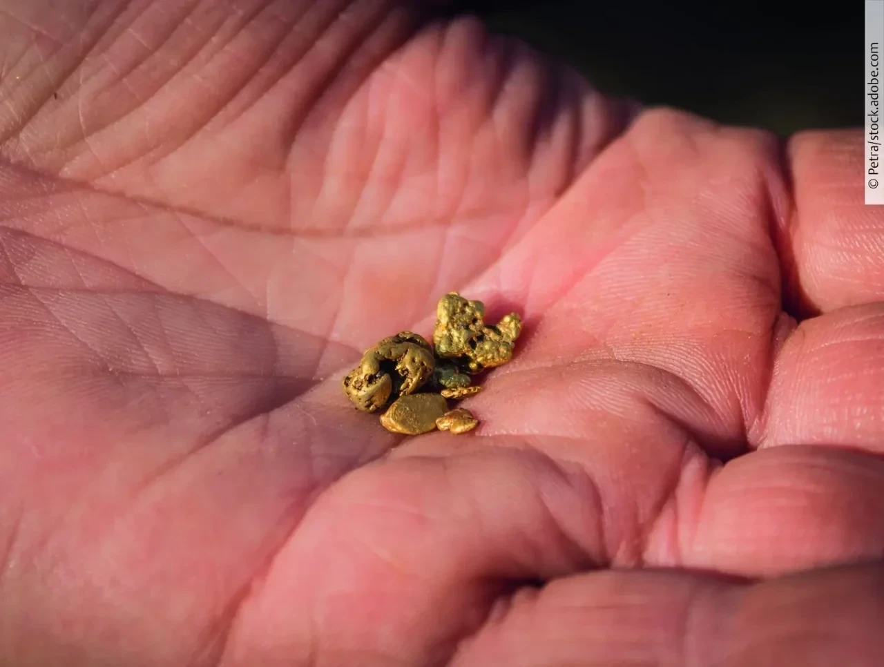 Handoberfläche mit kleinen Goldklumpen